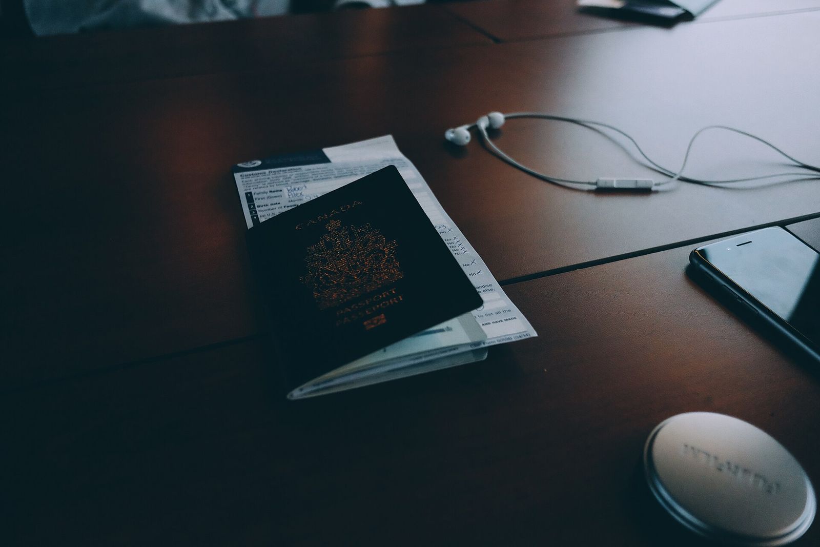 Pasaporte sobre unos formularios en una mesa de madera
